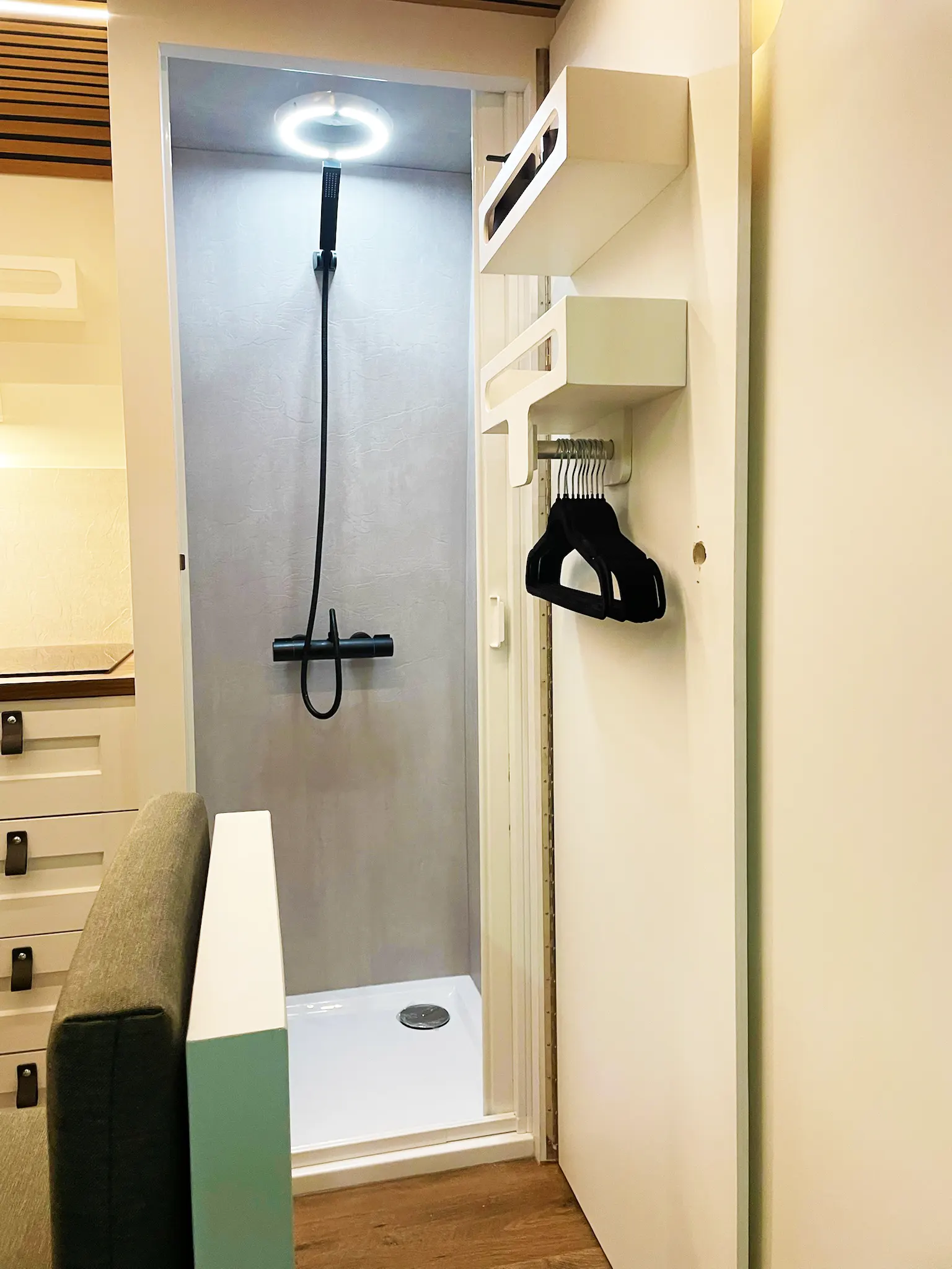 Volwaardige douche met opberg ruimte en kleerhanger in een camper Van van Granada Beach