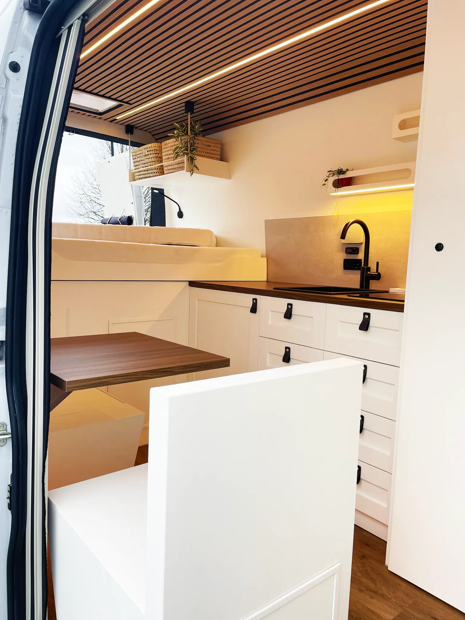 Gezellig interieur met vaste tafel en zitplaatsen in een camper Van van Granada Beach